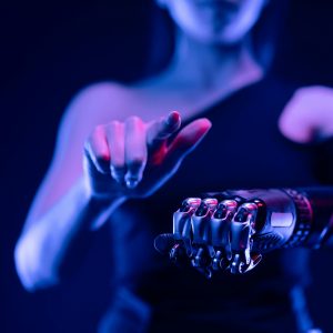 Close-up of a robotic hand with a woman pointing, showcasing advanced prosthetic technology.